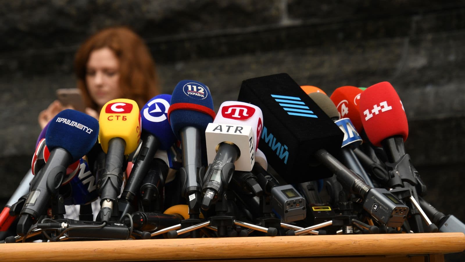 Kilkanaście mikrofonów z logotypami stacji ustawionych przed konferencją prasową