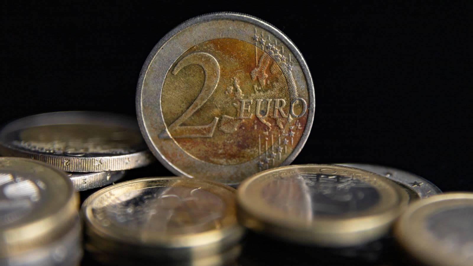 Makro monet euro ułożonych w stos na czarnym tle